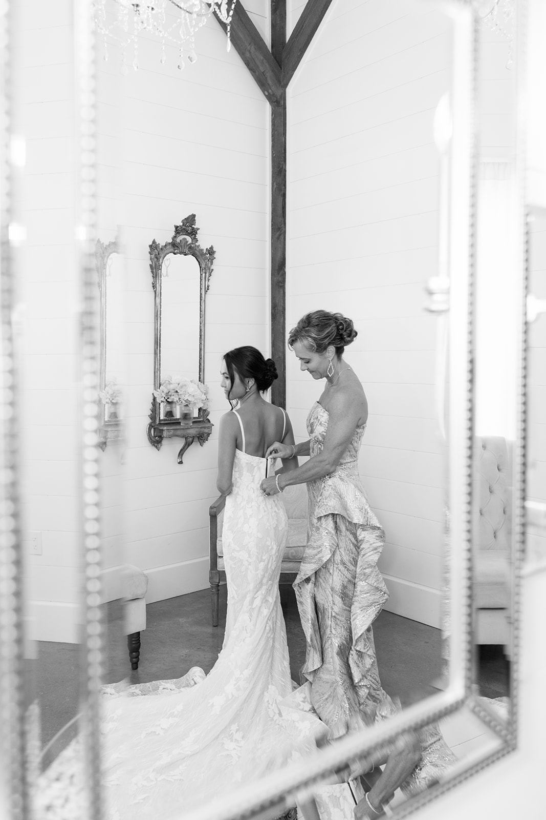Mother of the bride zips her daughter's wedding dress in the timeless wedding photo