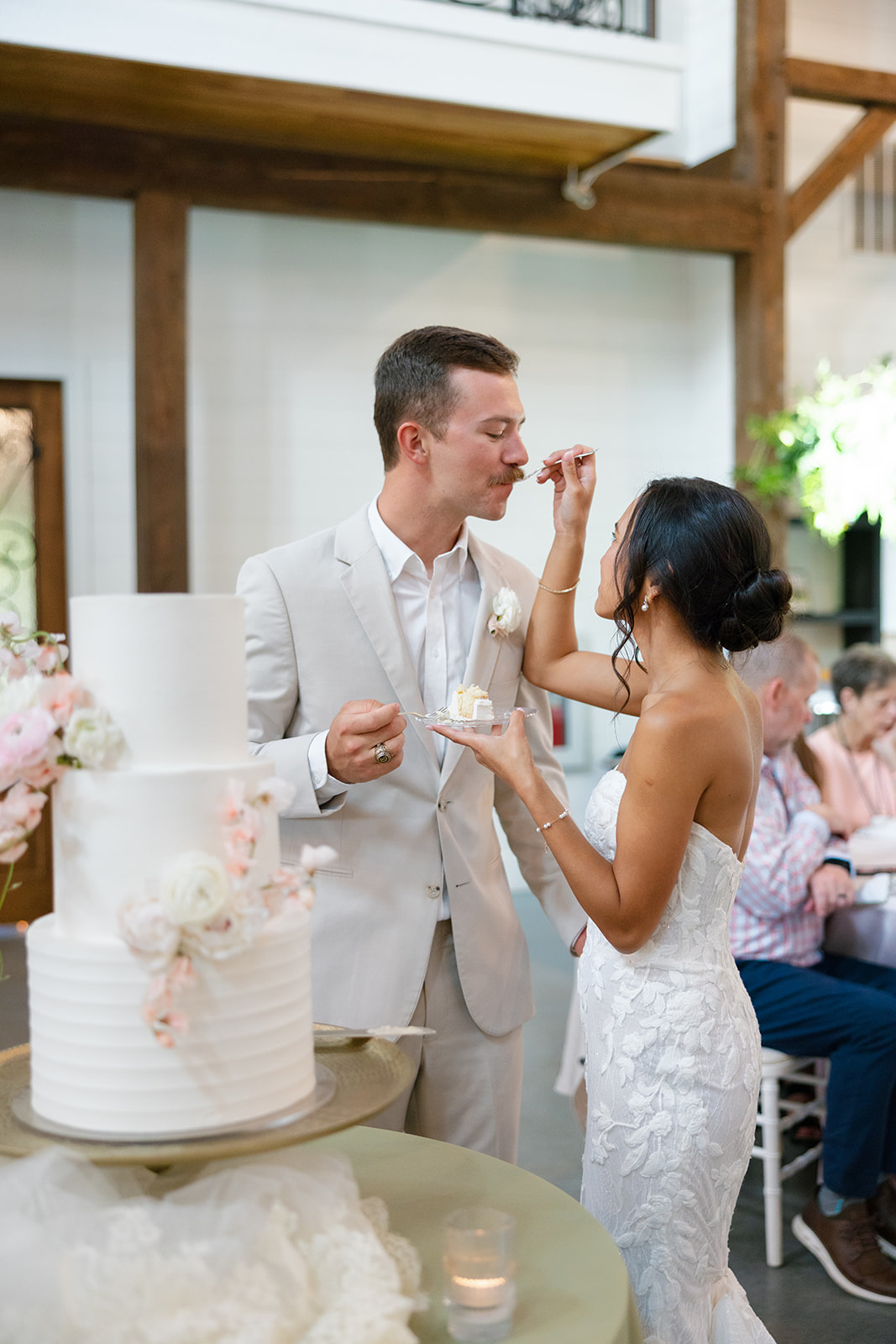 Bride and groom share a bite of their wedding cake at their South Carolina wedding reception