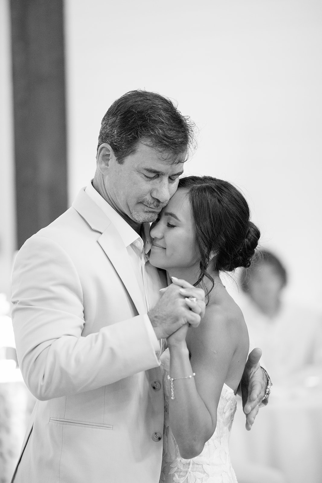 The father of the bride shares a sweet hug as he dances during the father-daughter dance