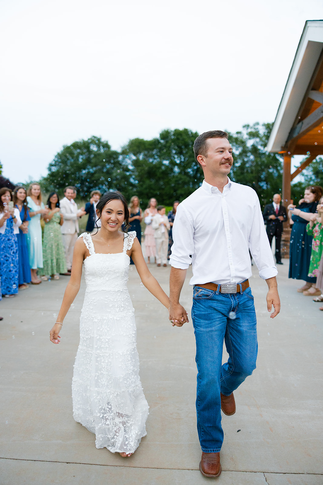 groom walks happily with the bride as they leave their South Carolina wedding