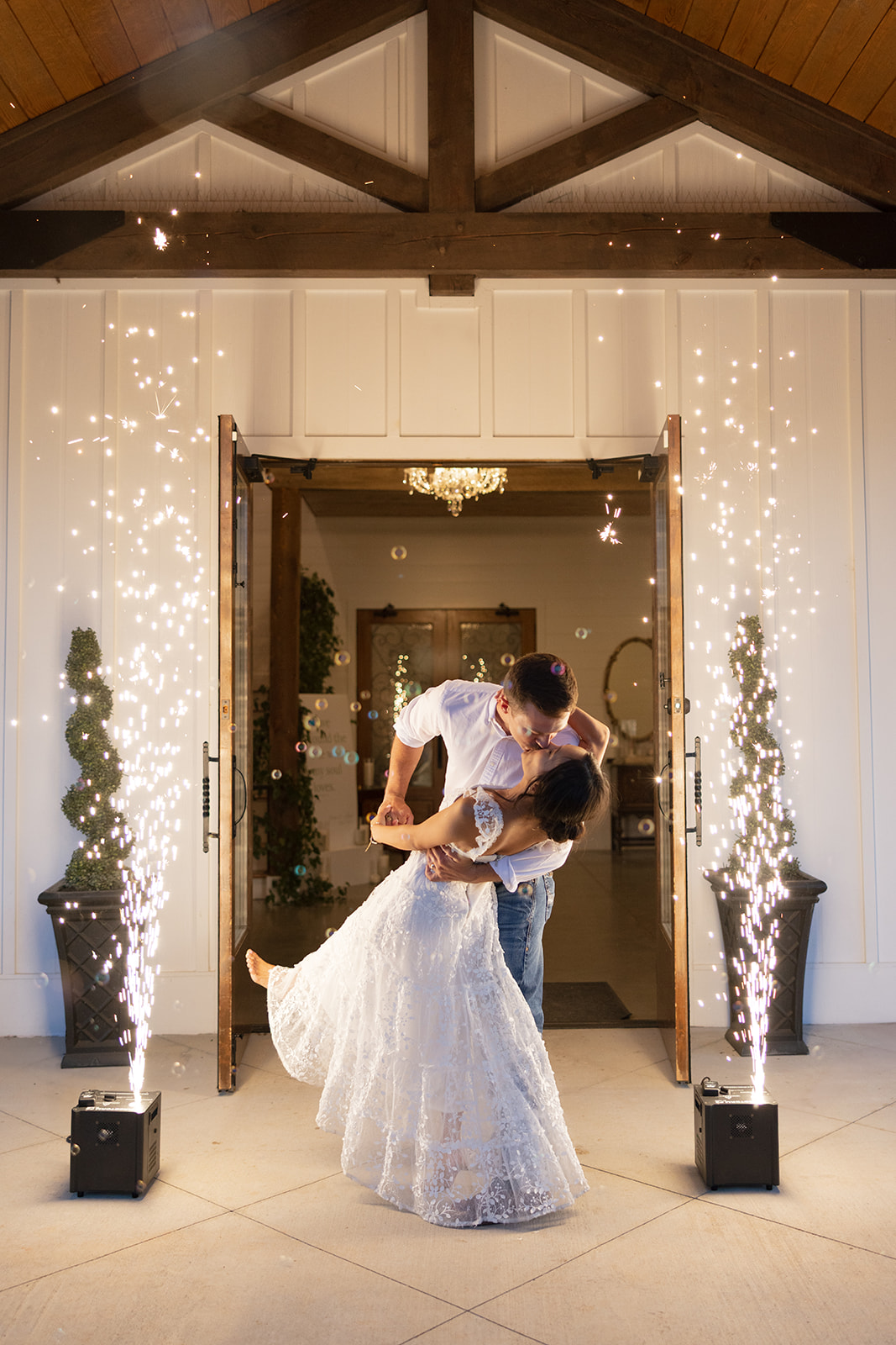 Bride and groom share a sweet kiss as they exit their wedding reception