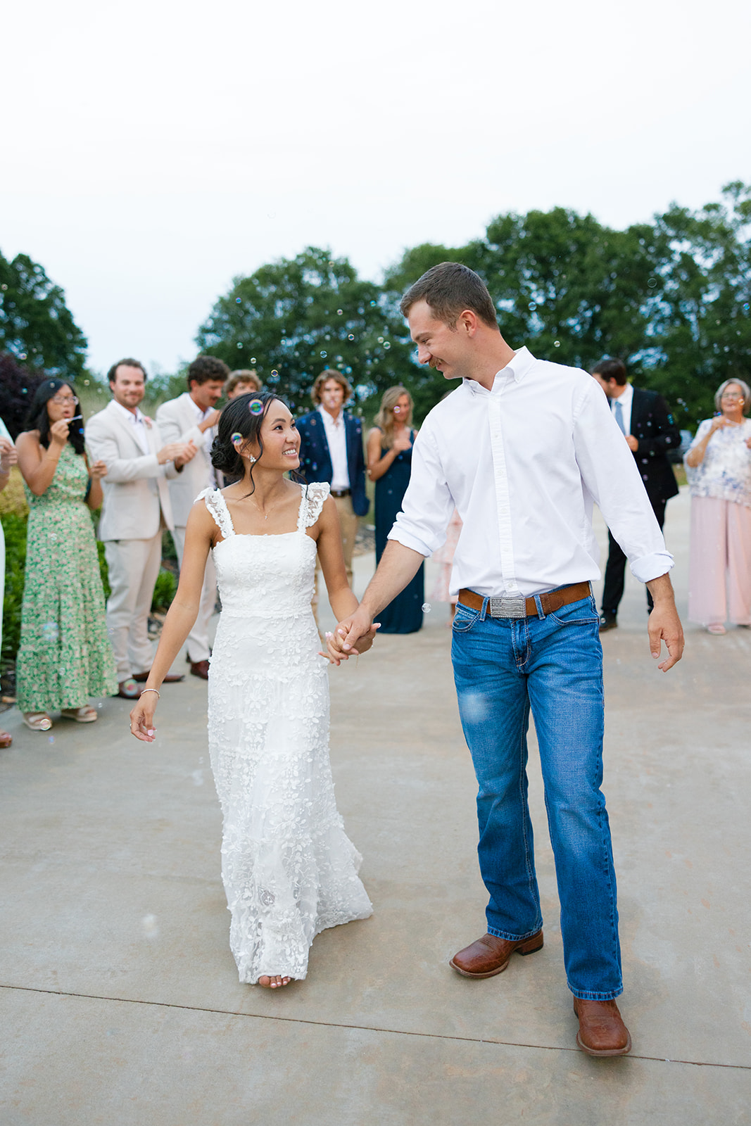 groom walks hand in hand with the bride as they leave their South Carolina wedding