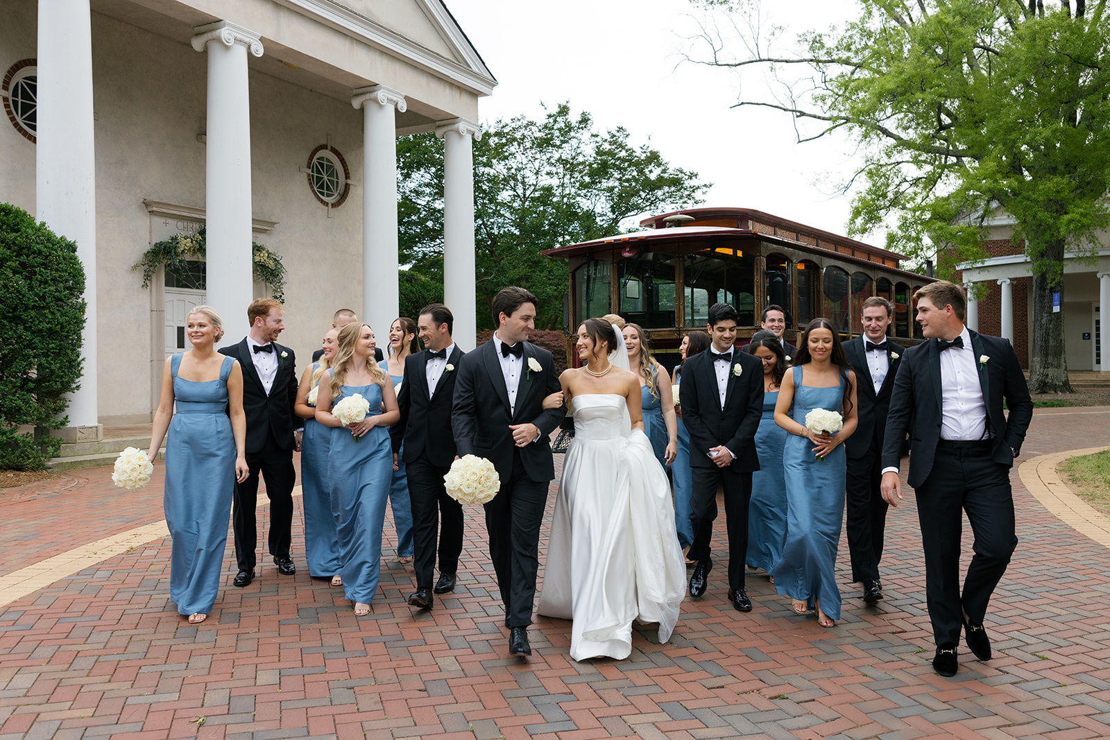 bride and groom with their bridal party walking to trolley to the wedding venue