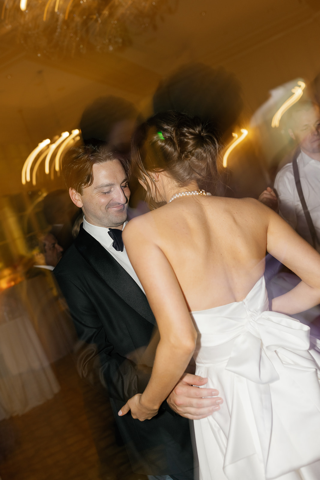 Bride and groom dancing closely with motion blur capturing the energy of the reception.