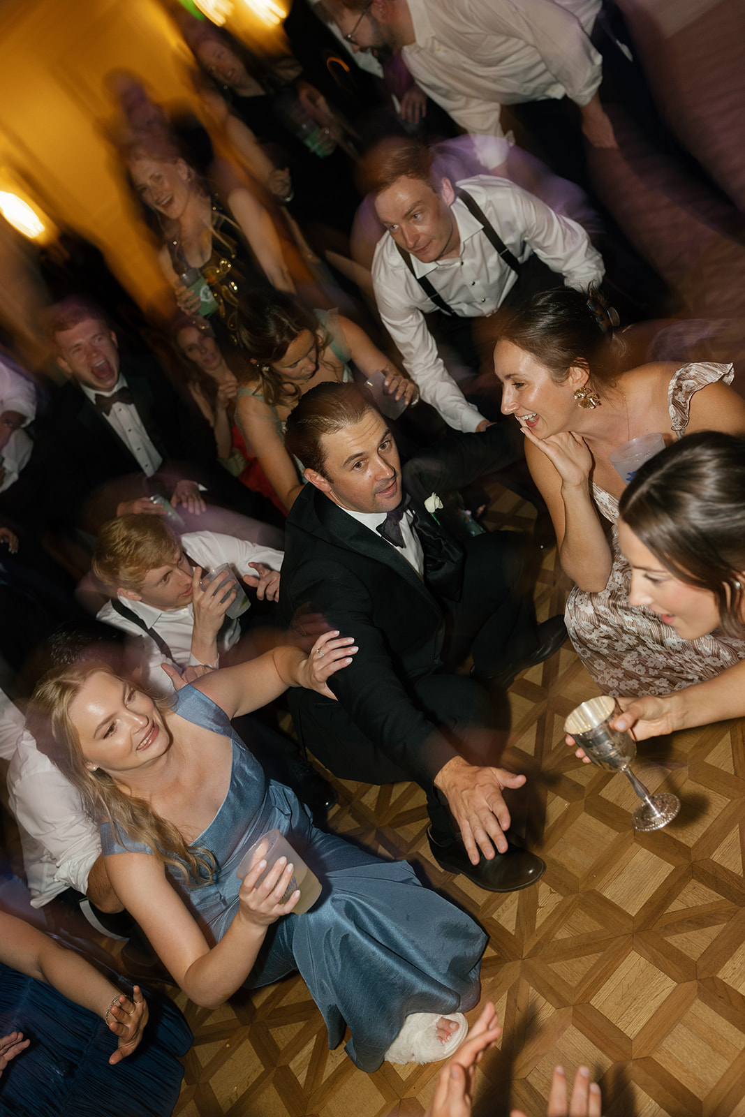 Guests smiling and holding drinks on the dance floor with a fun party atmosphere.