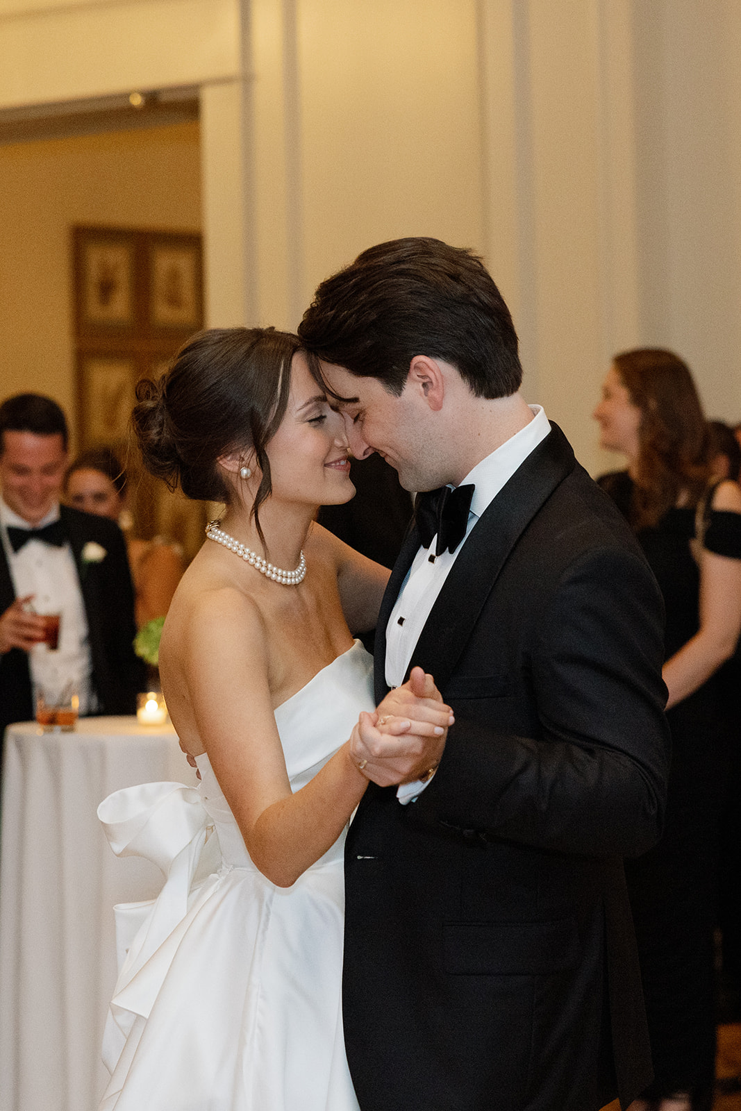 Bride and groom share a romantic first dance, smiling with their foreheads touching during their wedding reception.
