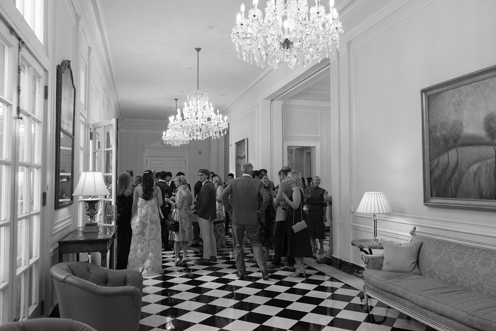 Wedding guests mingling during a rehearsal dinner at Duke Mansion in Charlotte, NC, captured as part of a wedding photography package.