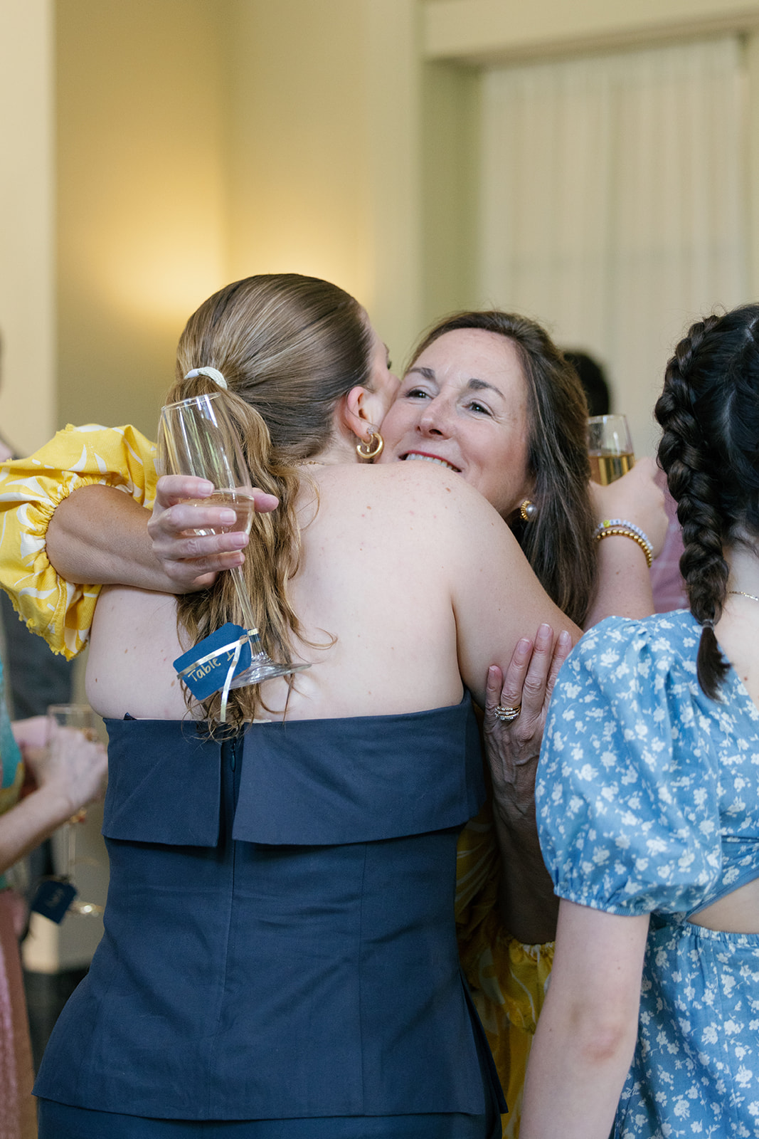 Two guests sharing a heartfelt hug during Bri and Henry’s rehearsal dinner at Duke Mansion in Charlotte, NC