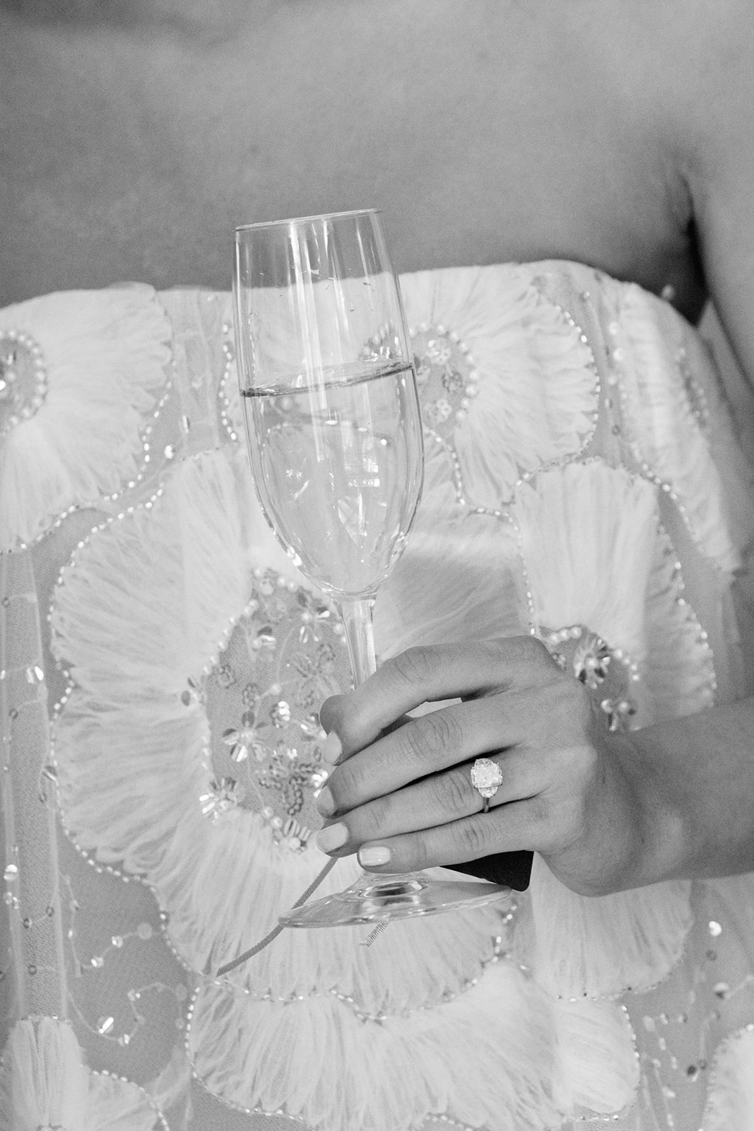 black and white detail shot of the bride's dress and ring at her rehearsal dinner