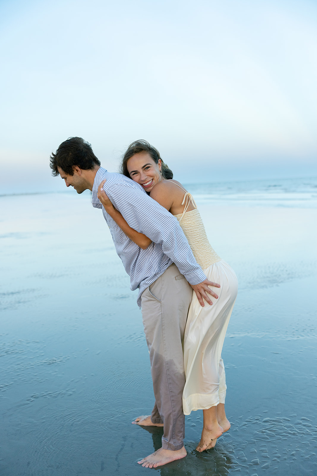The bride-to-be hugs her fiancé from behind during their Charleston SC engagement photos