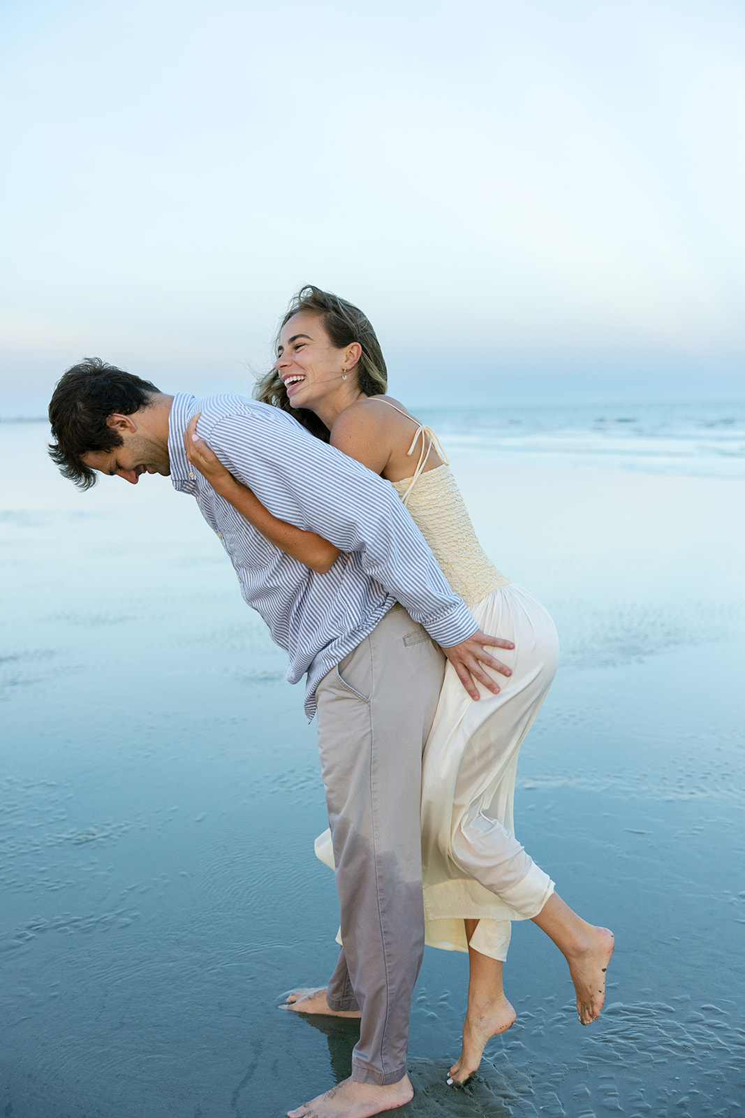 The bride-to-be hugs her fiancé from behind during their Charleston SC engagement photos
