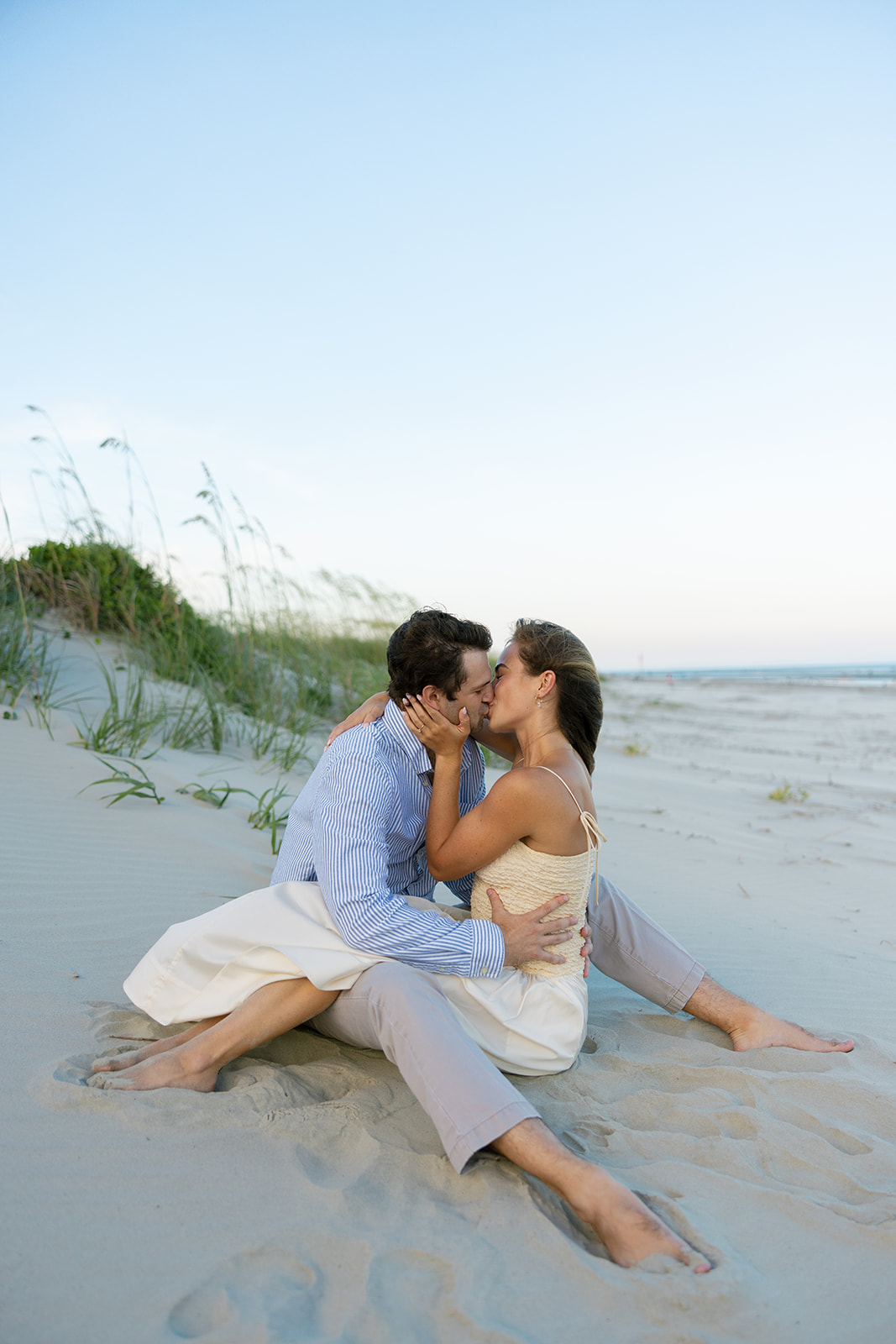 Romantic kiss on the sand dunes during Charleston SC engagement photos at Sullivan’s Island.