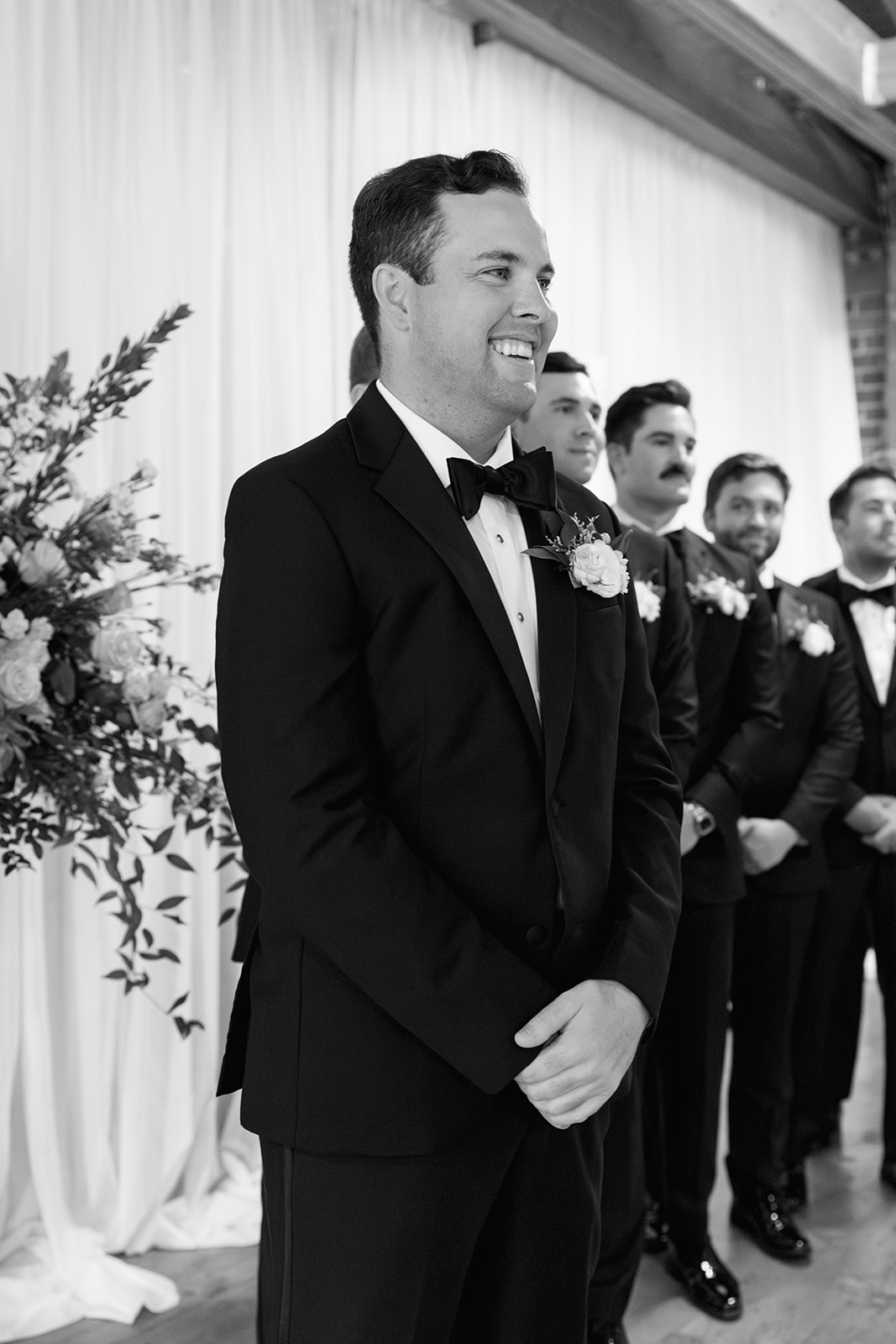 Groom smiling as he sees his bride walking toward him during their Greenville SC wedding ceremony.