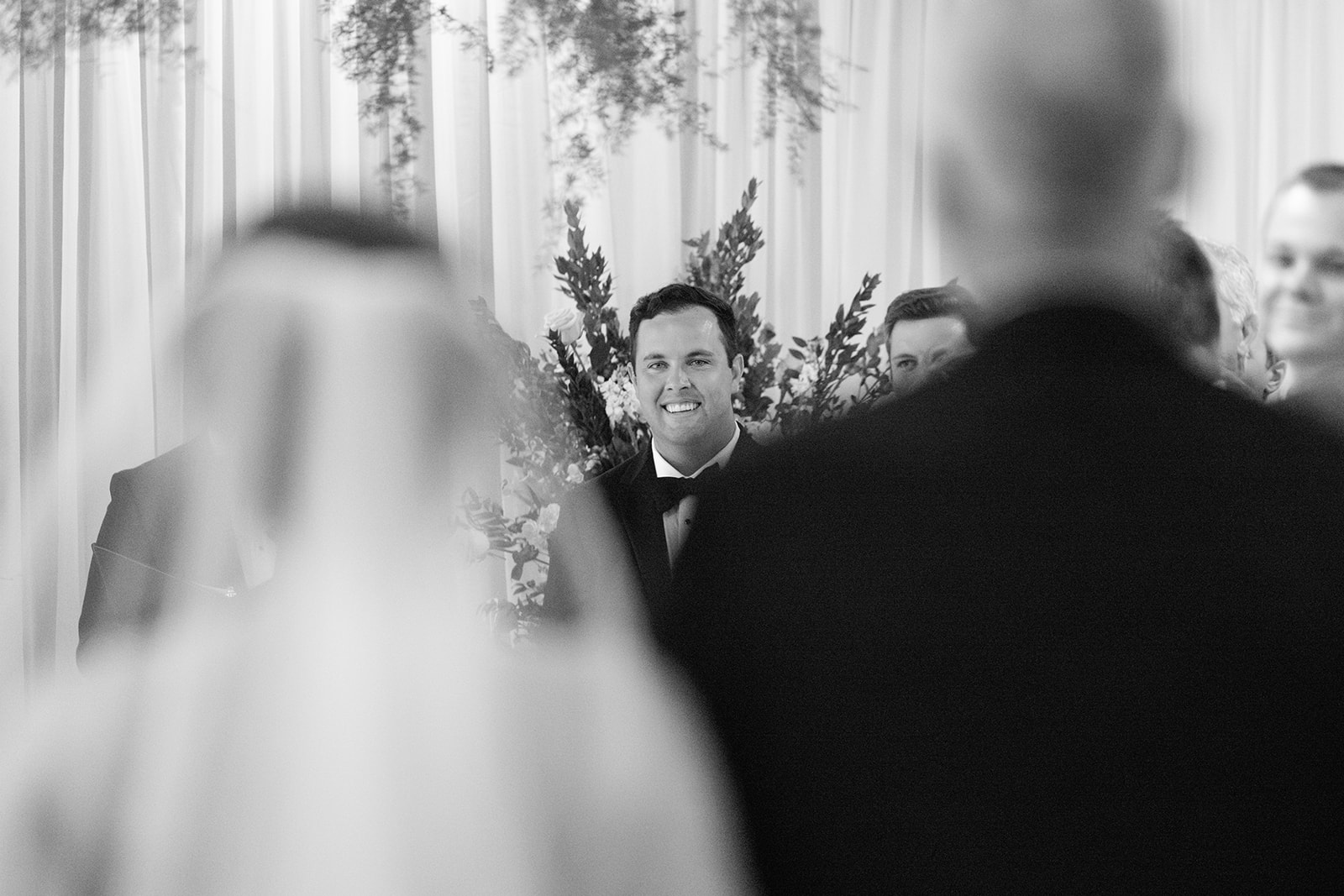 Groom smiling at the altar with his groomsmen lined up behind him during a Greenville SC wedding ceremony.