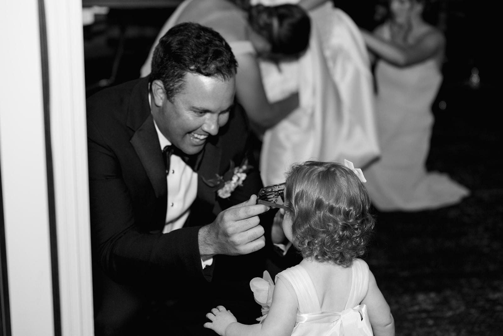 groom shares a smile with the flower girl