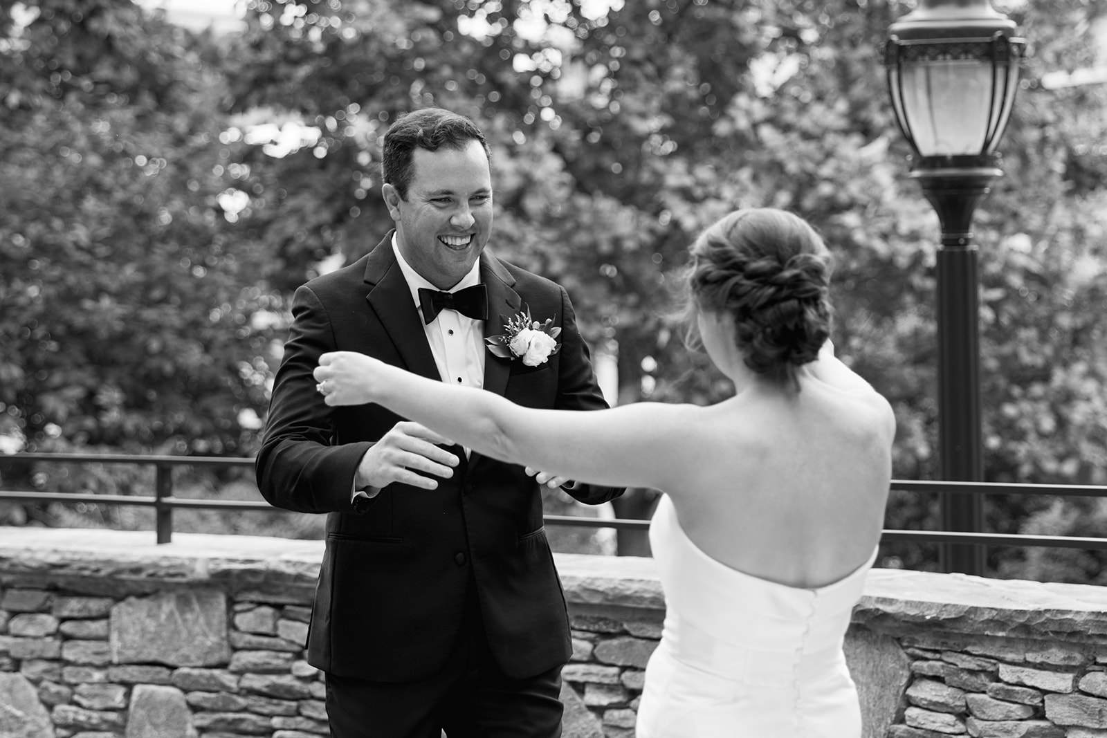 Bride and groom smiling at each other during their first look outside Huguenot Mill in Greenville, SC.

