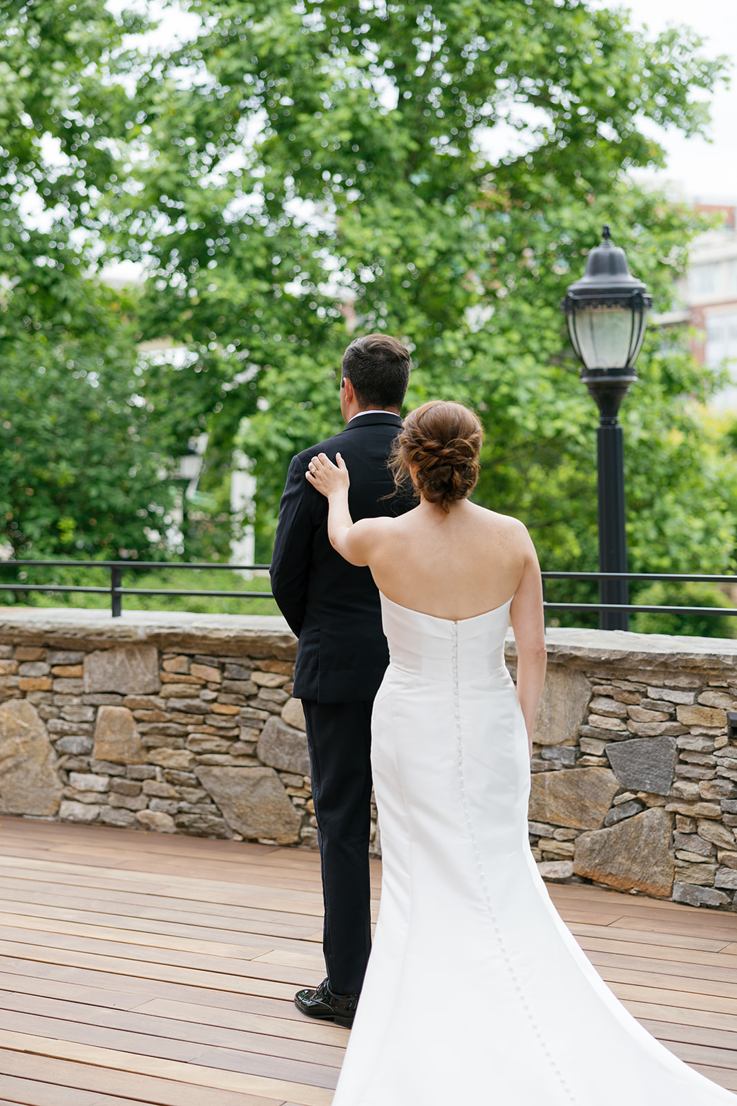 Bride reaching out to touch the groom during their first look outside their Greenville SC wedding venue.