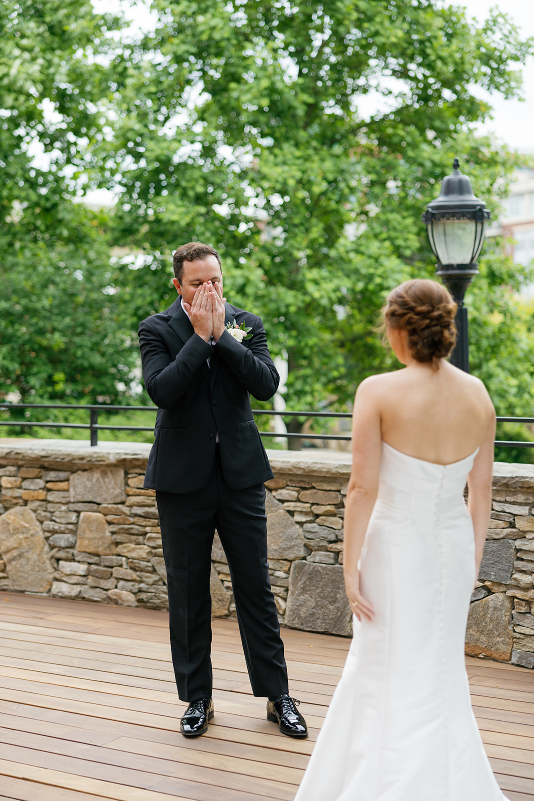 Groom covering his mouth in awe as he reacts to seeing his bride in her wedding gown at Huguenot Loft in Greenville, SC.