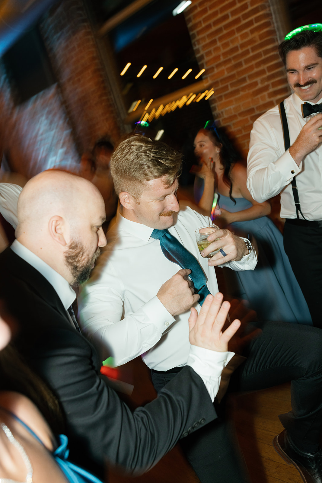 Wedding guests dancing with drinks in hand during the lively reception at Huguenot Loft in Greenville, SC.