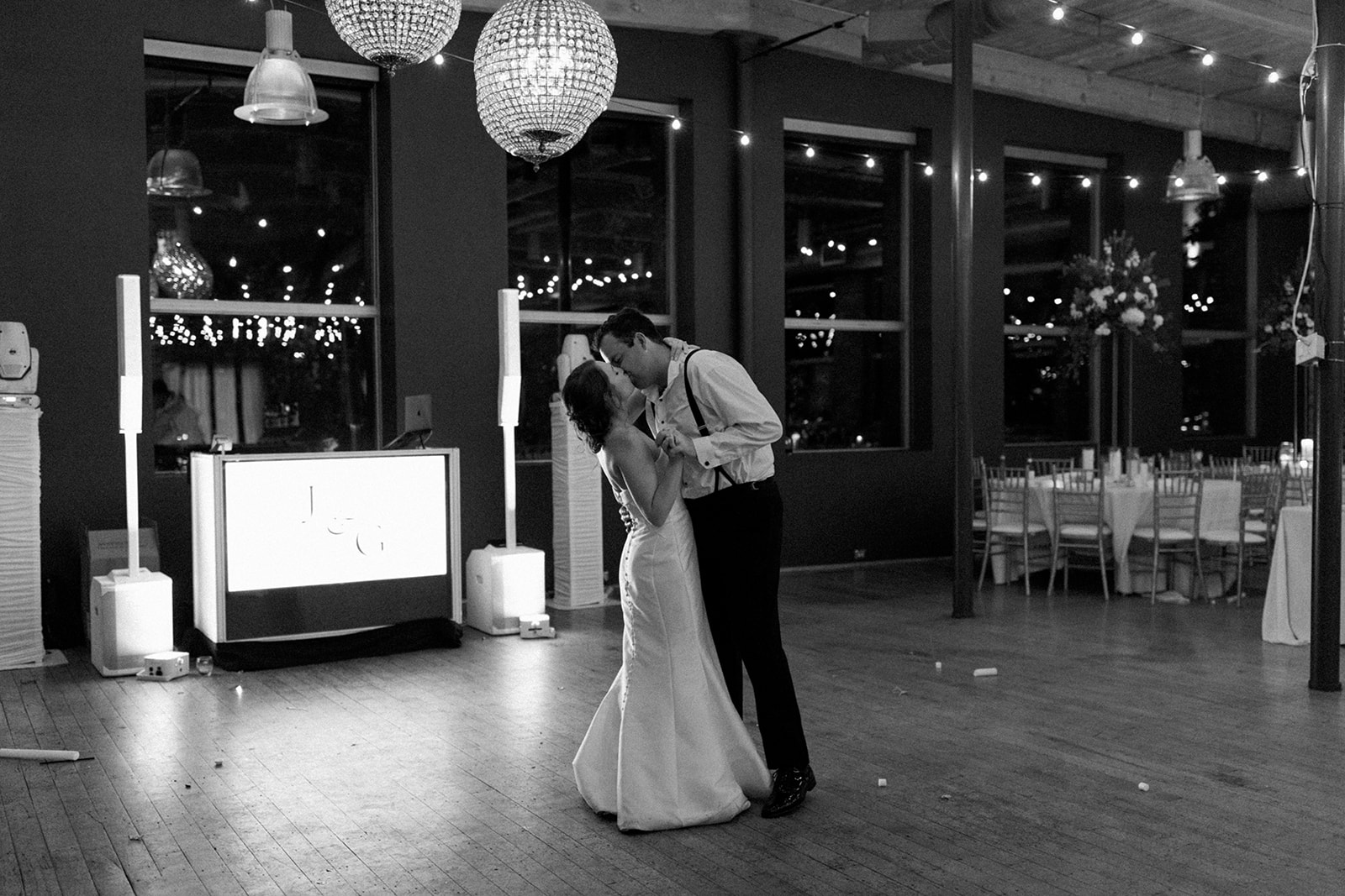 Bride and groom share a quiet last dance at Huguenot Loft, surrounded by glowing chandeliers and exposed brick.
