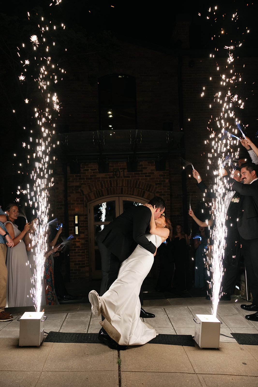 Dramatic kiss under sparkler fountains during the couple’s nighttime exit at Huguenot Loft wedding venue in Greenville, SC.
