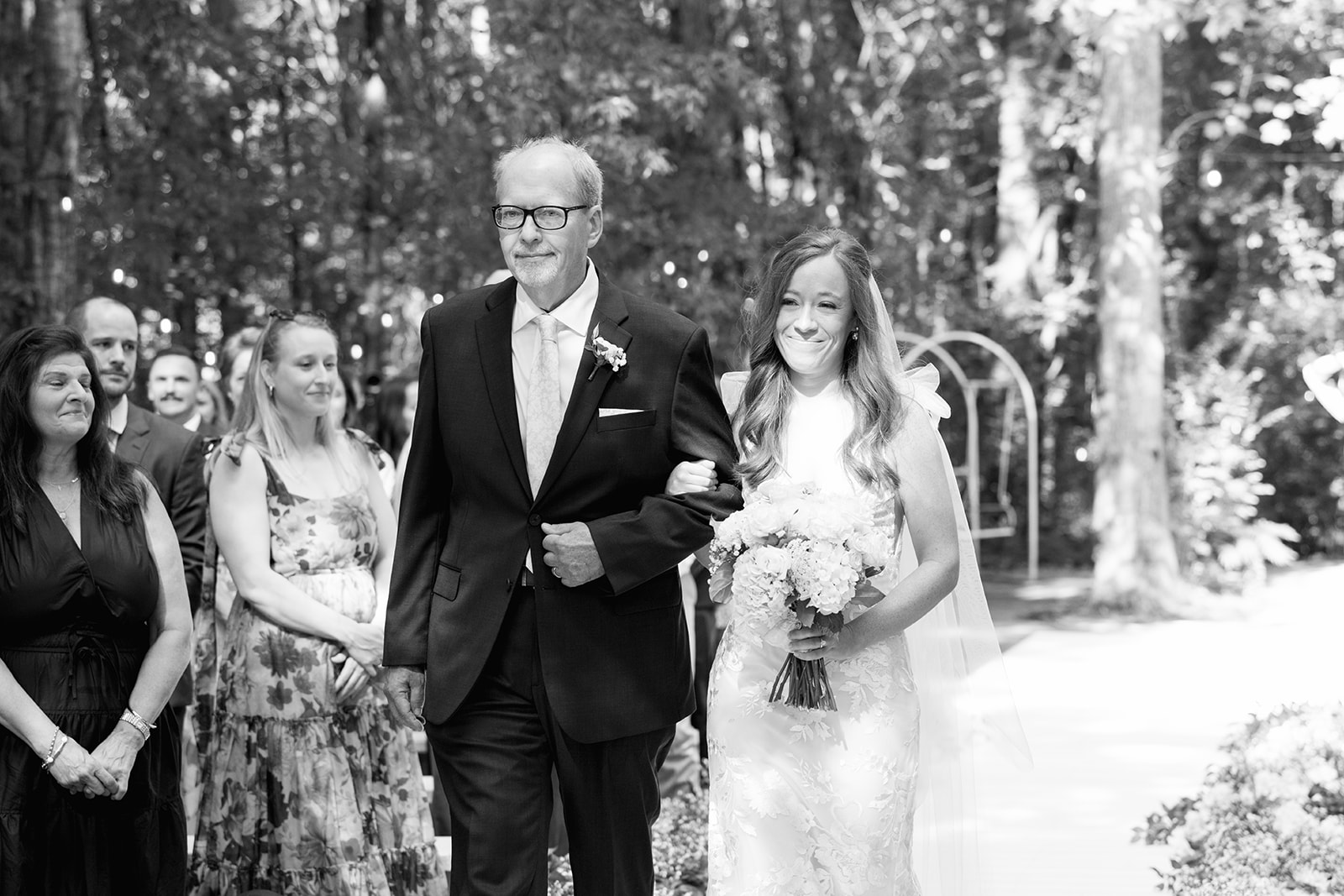 Emotional black-and-white photo of a bride and her father during the wedding processional, a timeless moment by a wedding photographer in Greenville, SC.
