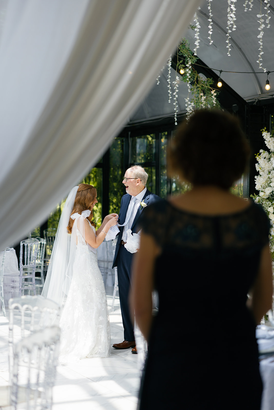 Bride shares a joyful first look with her father at Edinburgh West, while her mother watches from the background