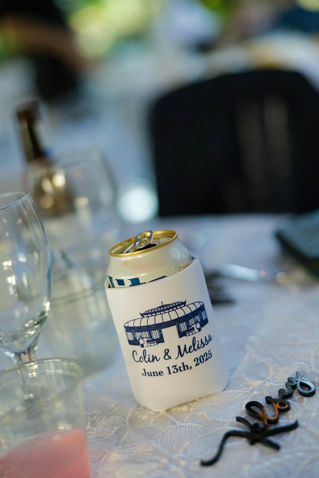 Close-up of a beer can cooler with couple’s names and wedding date, detail photo by a Greenville wedding photographer.