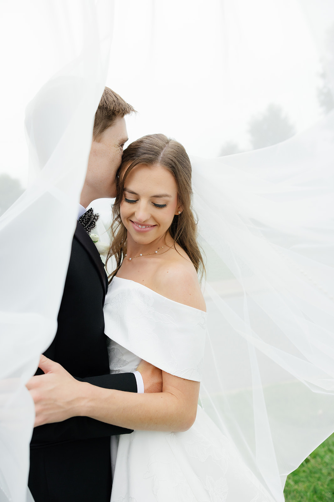 Bride and groom share a quiet moment under the bride’s veil