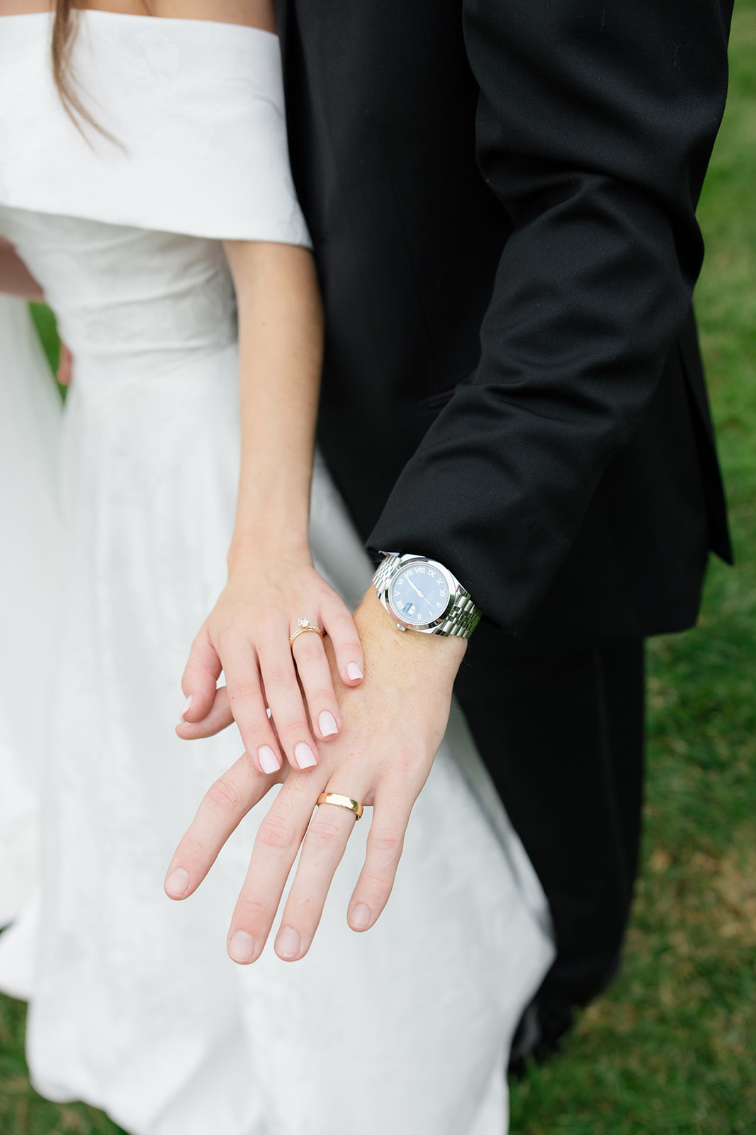 Close-up of bride’s hand resting on groom’s hand