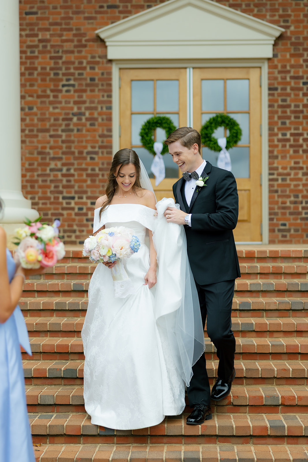 Bride and groom walking down the steps of Daniel Chapel at Furman University