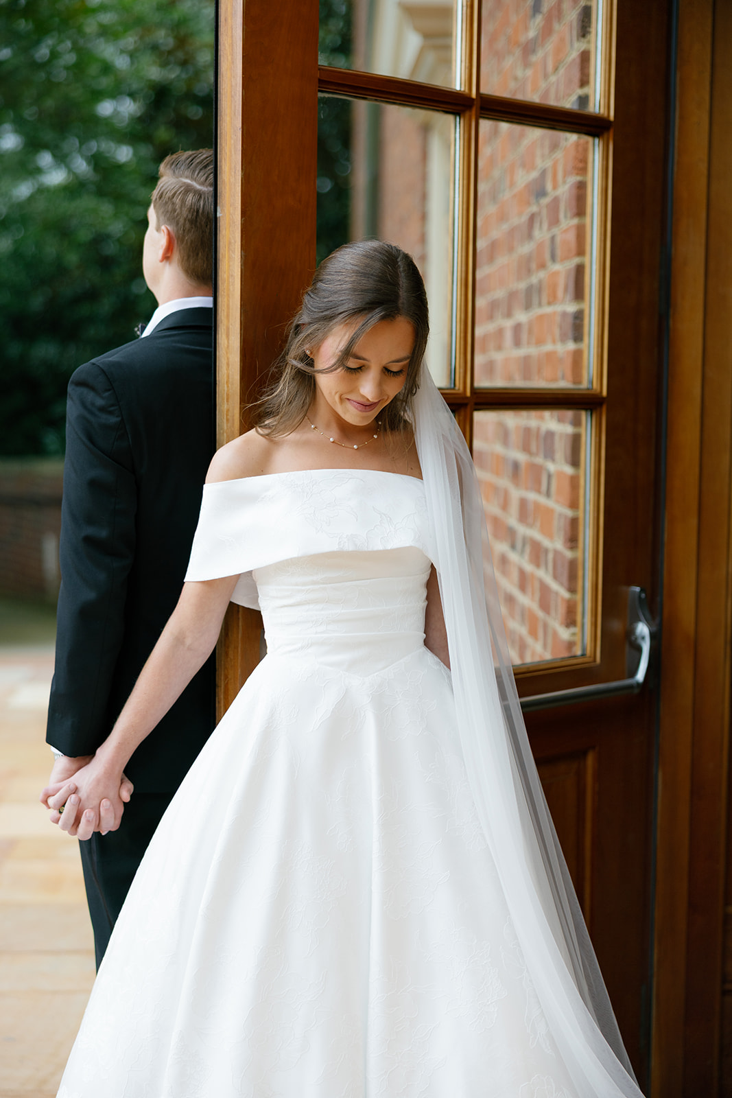Bride and groom share their first touch on the steps of Daniel Chapel at Furman University