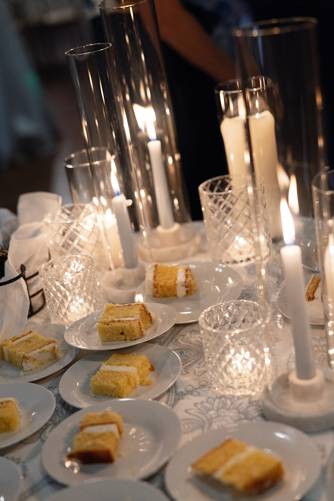 Moody candlelit table with slices of cake at a South Carolina Wedding