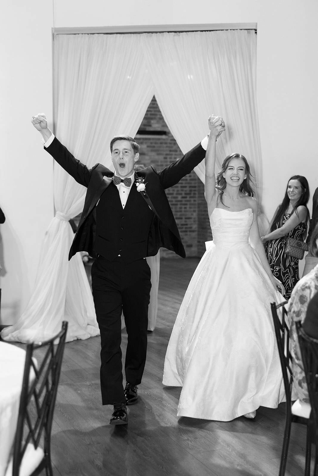 Bride and groom joyfully enter their reception