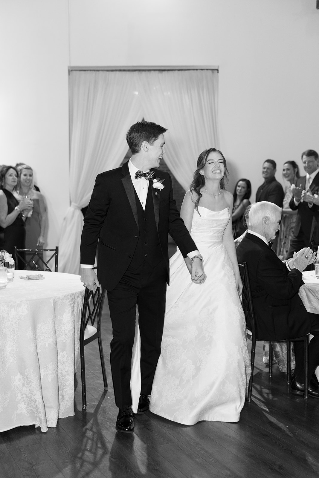 groom lovingly smiles at his bride as they enter their wedding reception