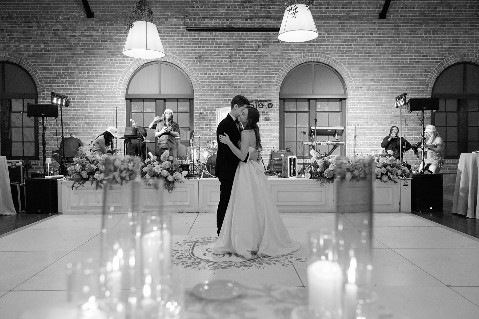 Romantic black-and-white photo of the couple’s first dance with a live band in the background at The L by Larkins.
