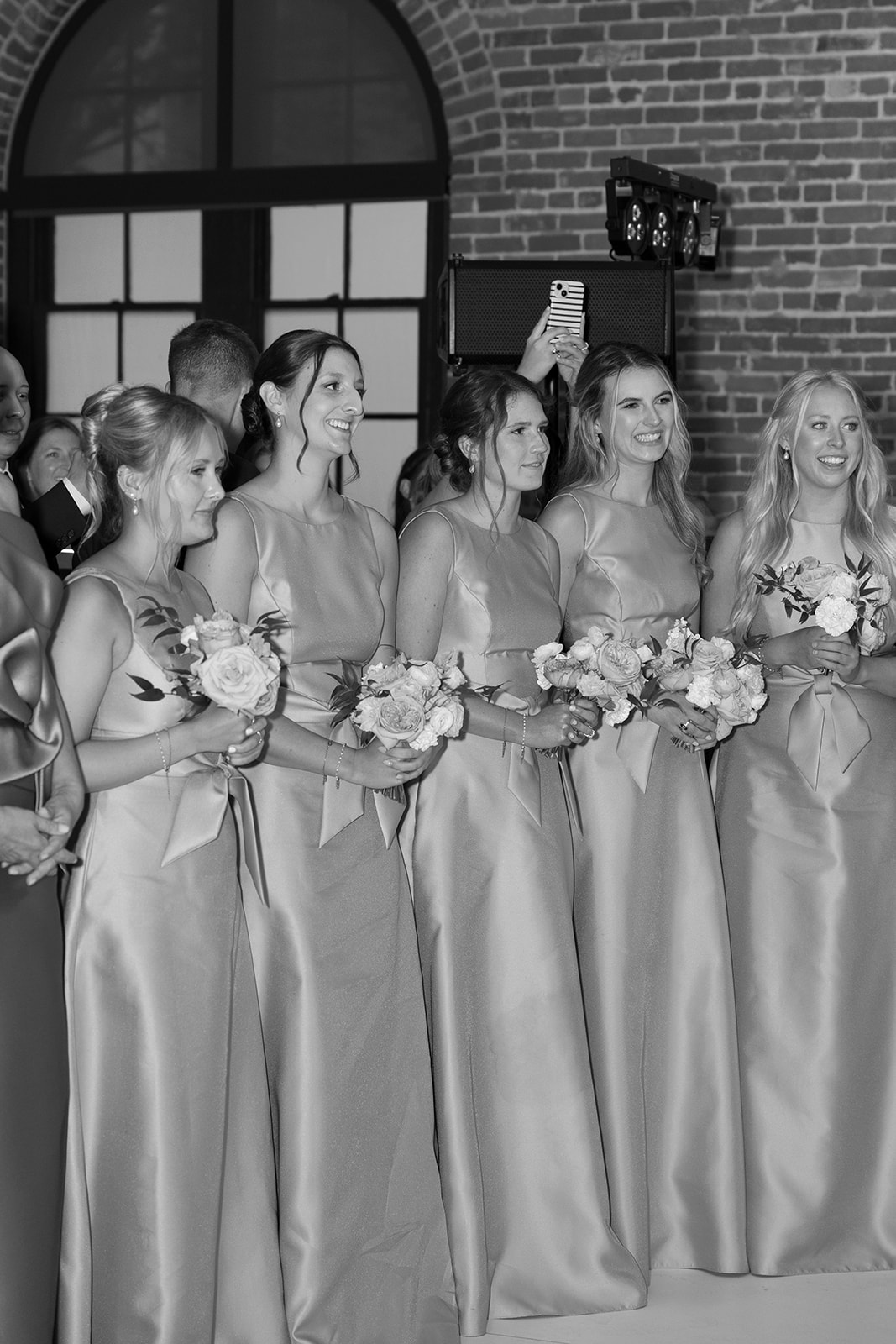 bridesmaids watch as the newlyweds share their first dance