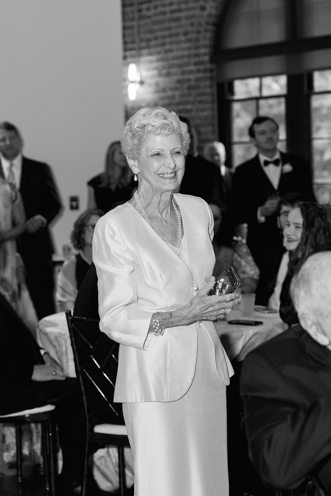 grandmother watches as the newlyweds share their first dance