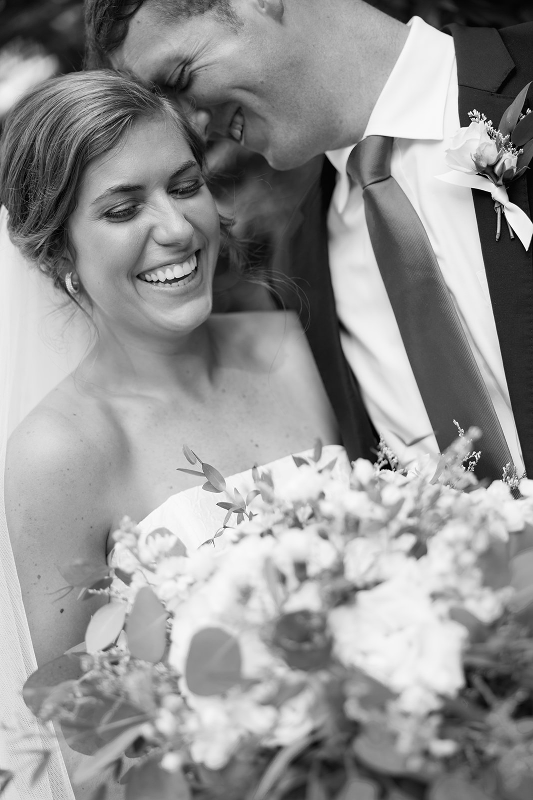 a candid moment of the wedding couple laughing together 
