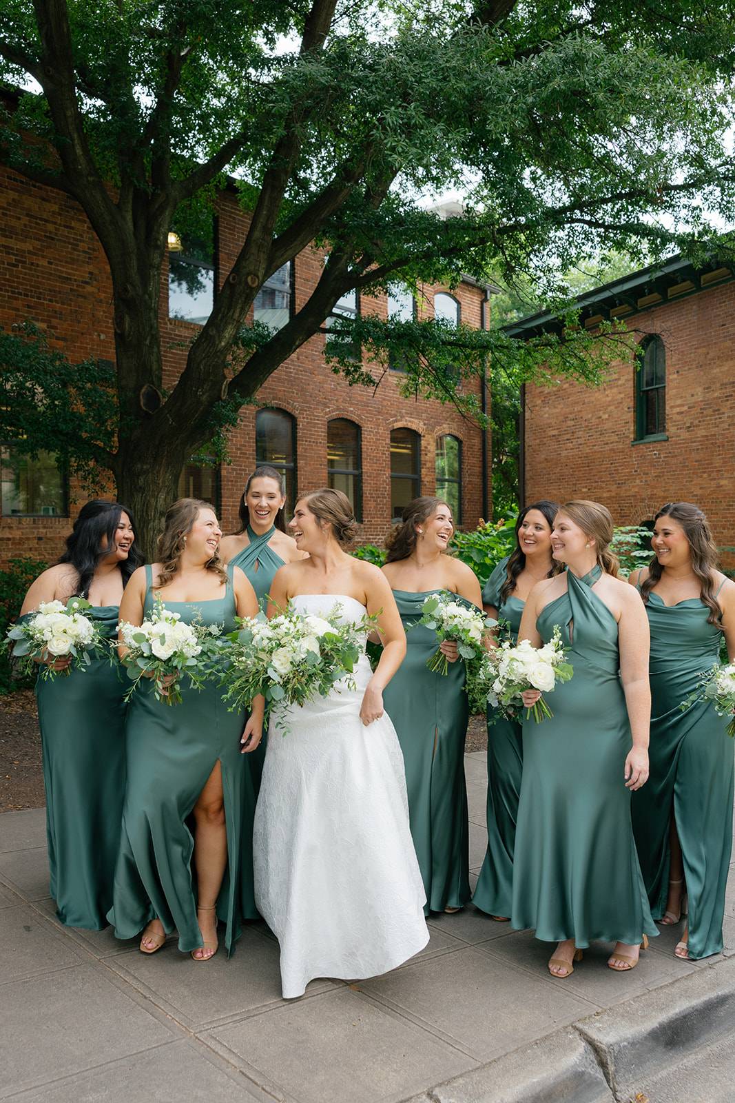 the bride and her bridesmaids smiling together during their portraits for a Greenville wedding 