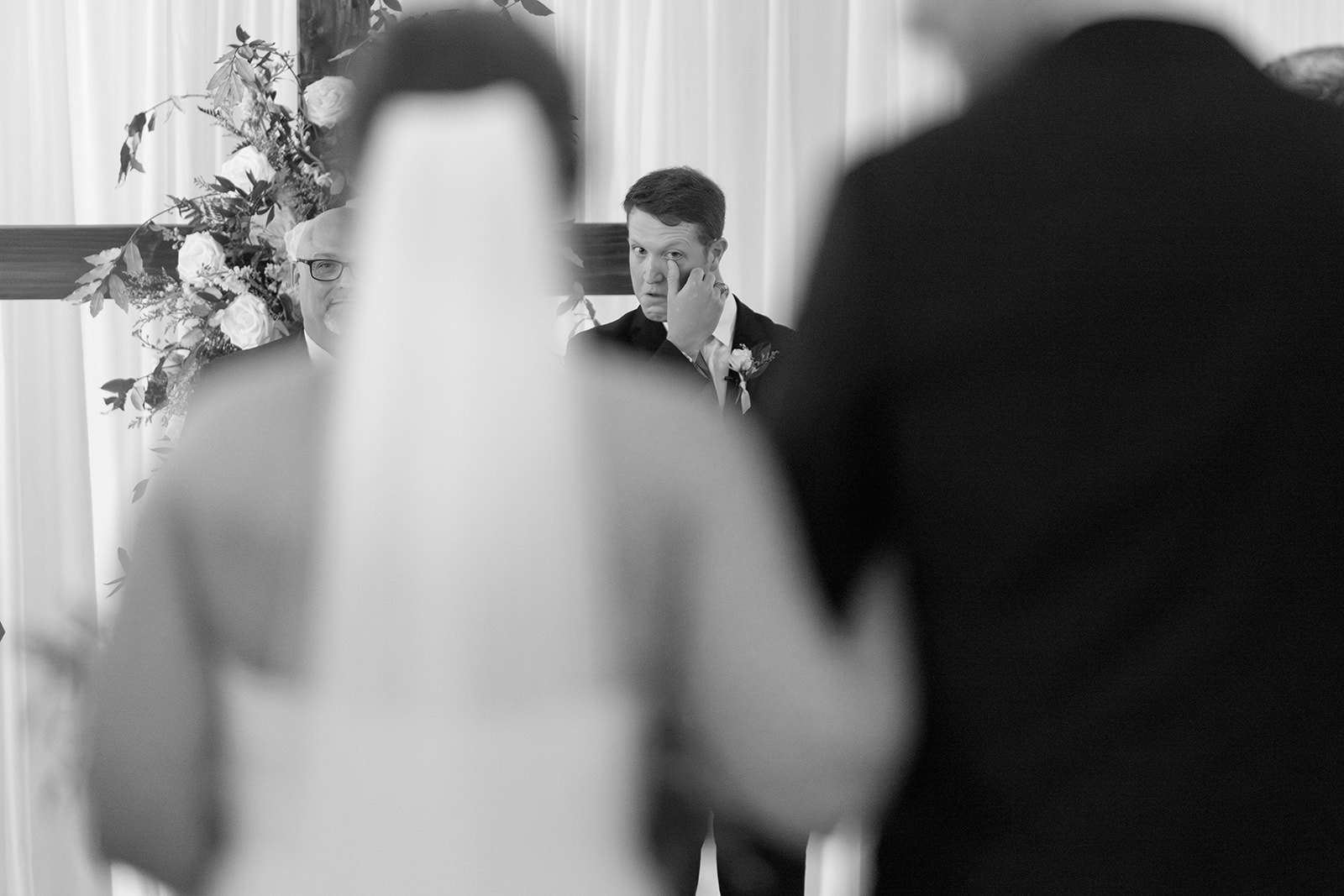 the groom wiping away a tear as he sees the bride for the first time on their wedding day 