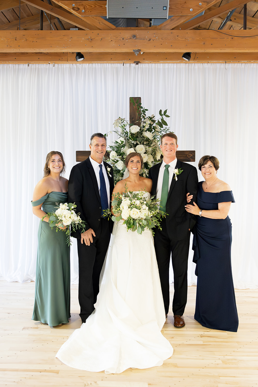 the bride and groom with her family for portraits