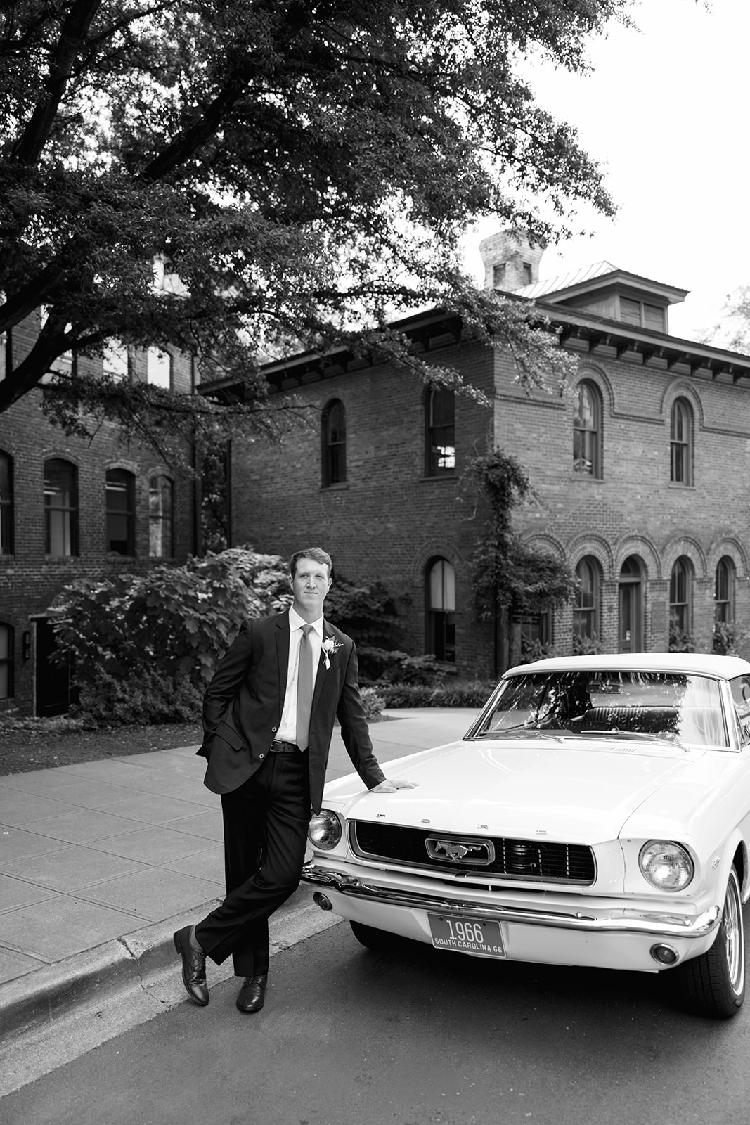 a groom leaning against a vintage car in South Carolina 